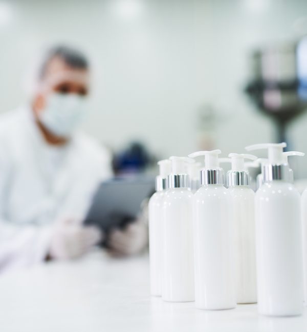 Row of cosmetics in front of a scientist in the fabric.